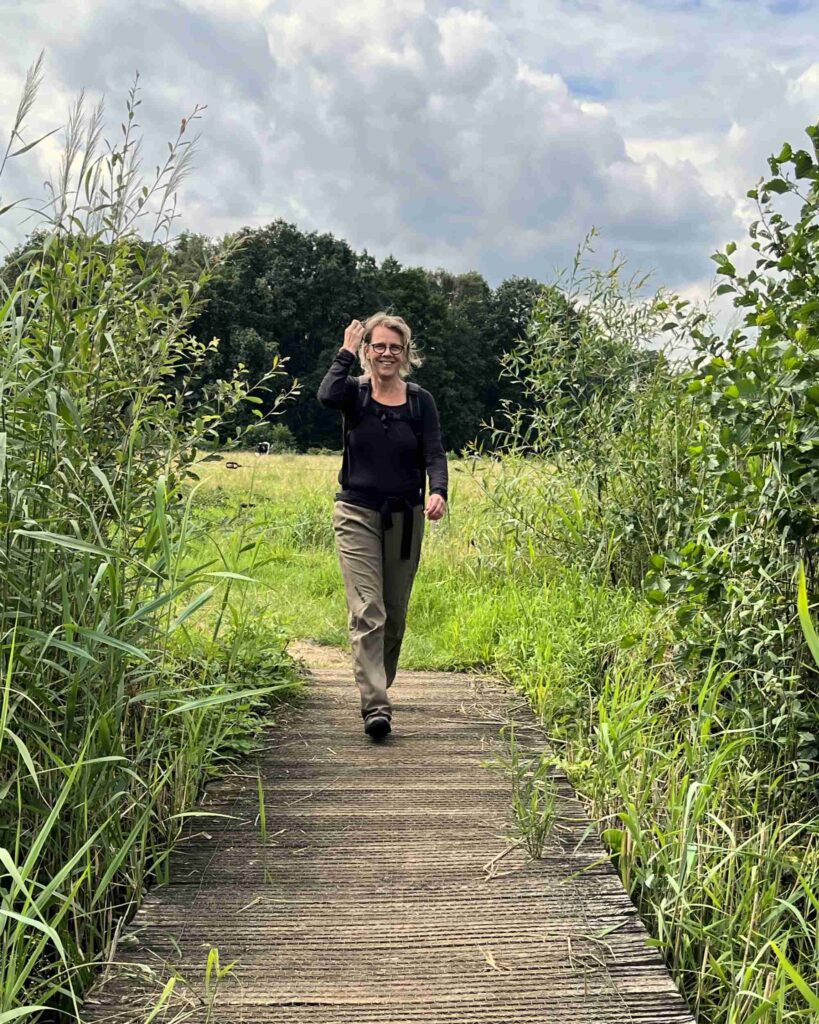 Wiesje komt wandelend over een bruggetje aanzetten.